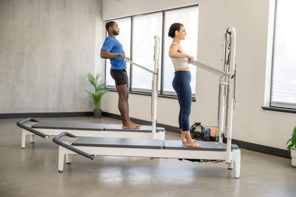 Kaks inimest kasutamas Allegro 2 Tower of Power seadeldist Pilates stuudios.