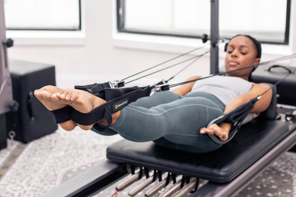 Inimene kasutab Pilates harjutuseks Allegro Reformer Konnectorit