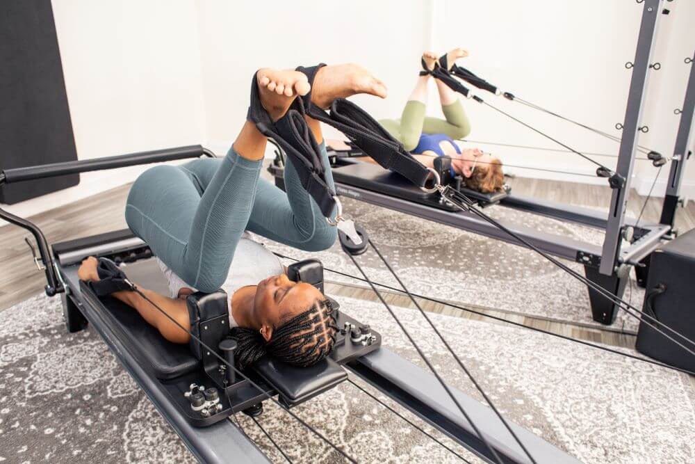 Kaks inimest kasutavad Pilates stuudios Allegro Reformer Konnectorit.