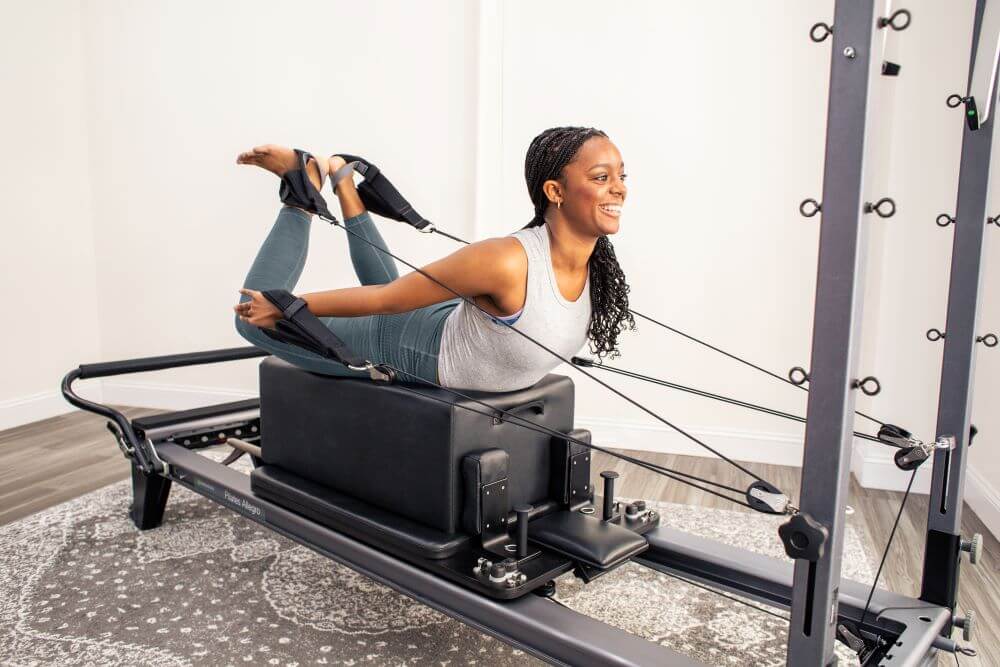 Inimene kasutab Pilates-harjutuseks Allegro Reformer Konnectorit.