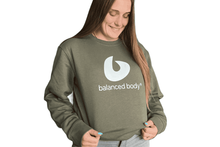 Woman wearing Balanced Body Crewneck Sweatshirt with logo.