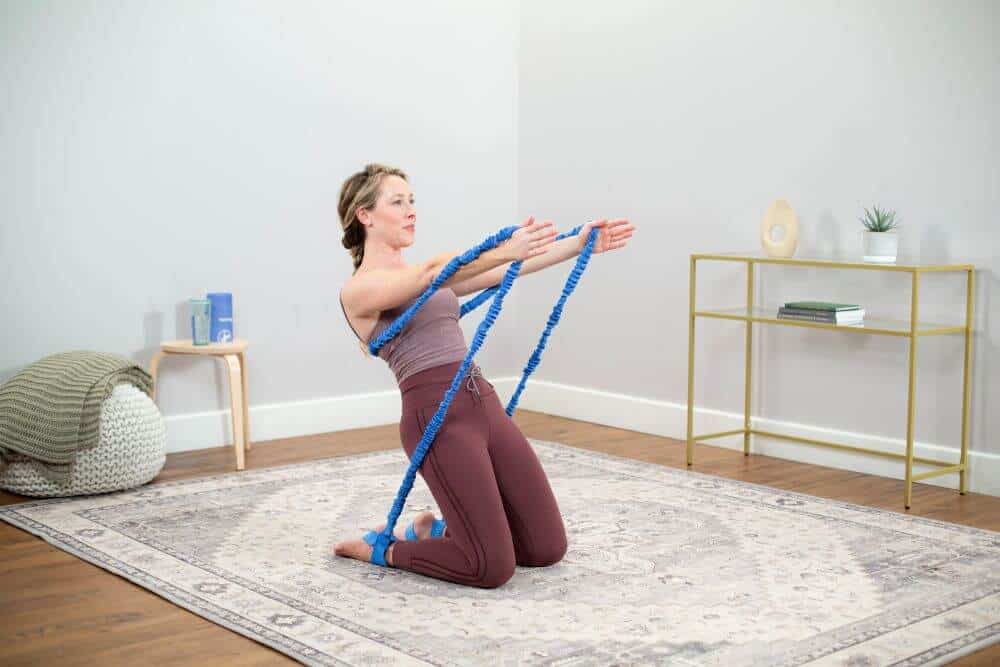 Person using Konnections Band for Pilates exercise on rug.