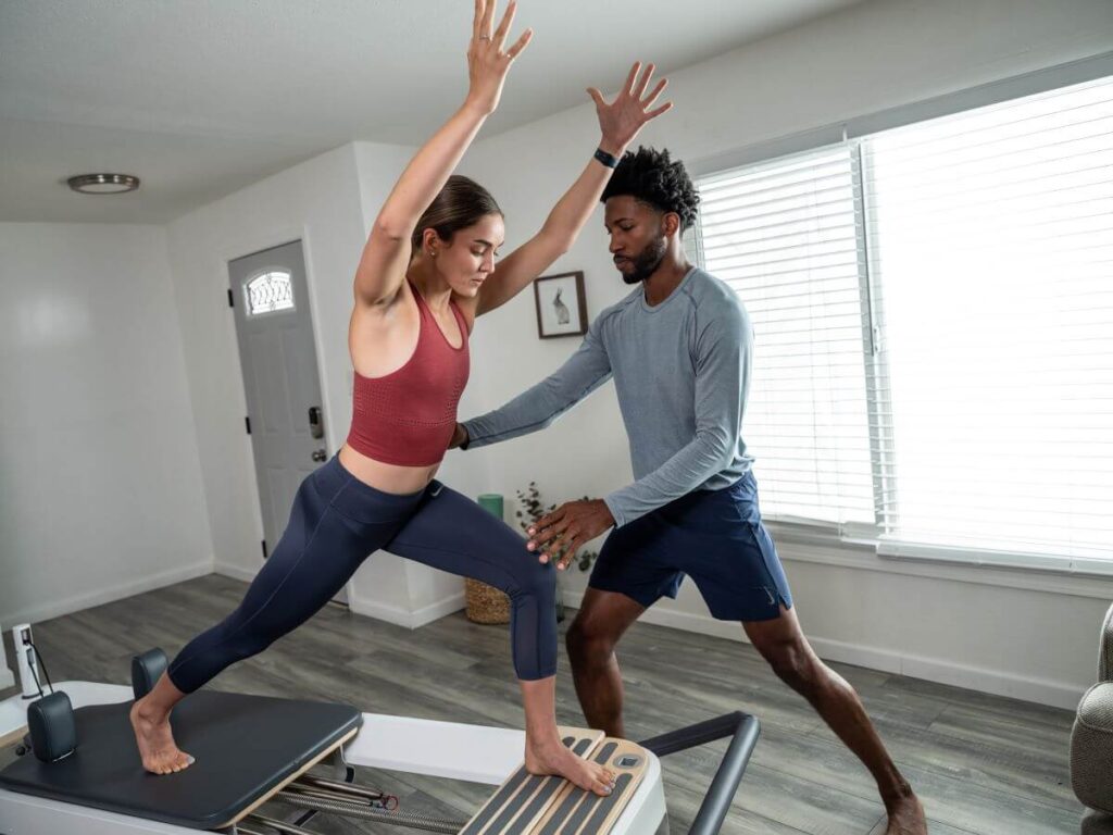 Инструктор помогает женщине использовать удлинитель стоячей платформы Allegro 2.