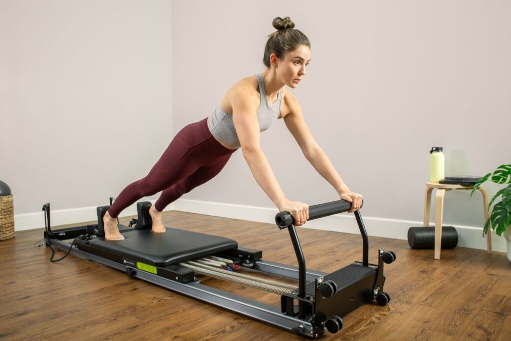 Женщина занимается на тренажёре Metro IQ Reformer для пилатеса в домашних условиях