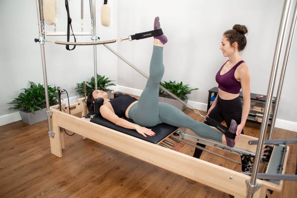 Комбинированный тренажёр Пилатес Реформер-Трапеция в использовании в студии.