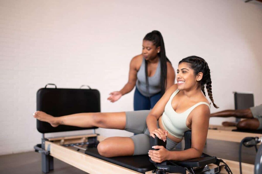 Pilatese instruktor juhendab õpilast Rialto Reformer hüppeplaadil