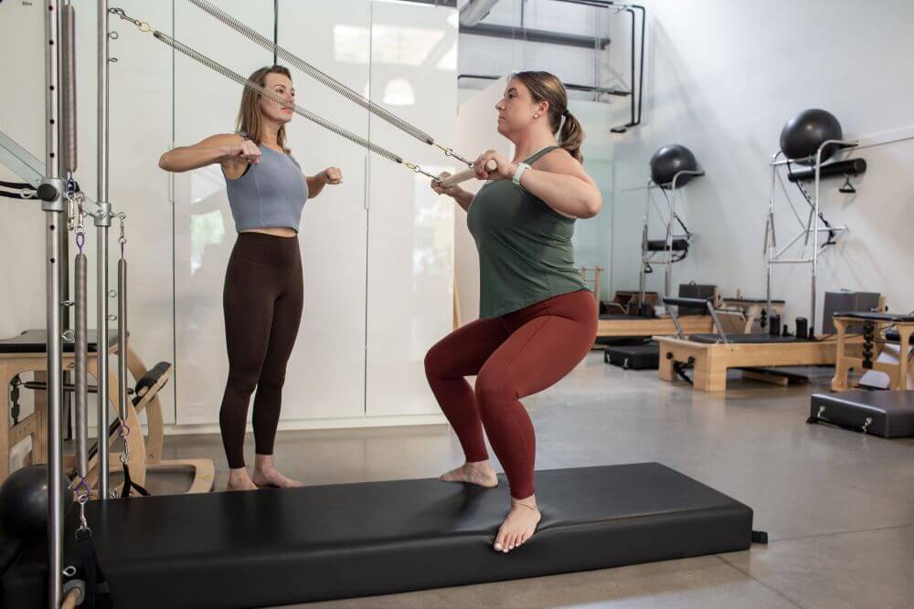 Pilates training with Wall Tower equipment in a studio setting.
