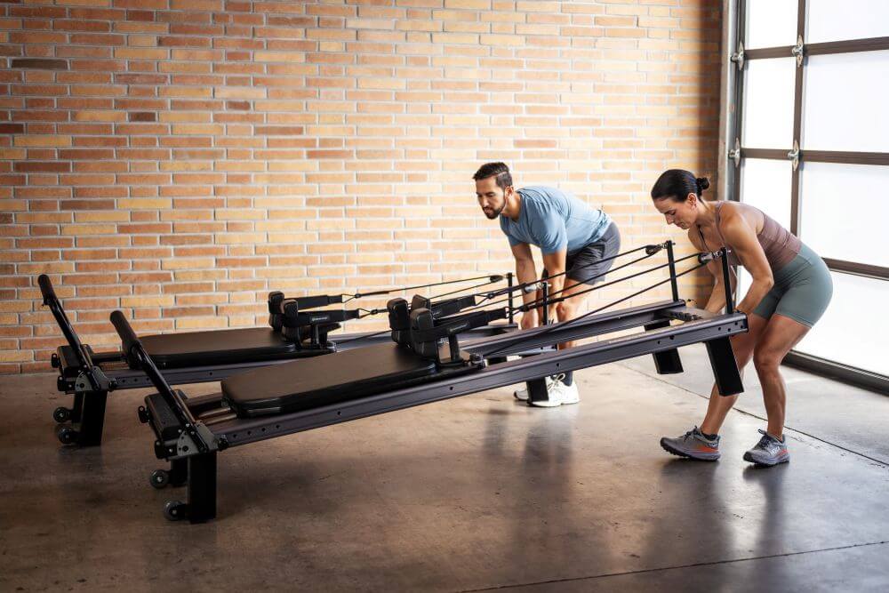 Тренеры собирают Allegro Nextgen Reformer в студии.