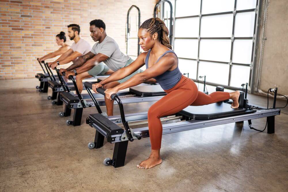 Группа занимается на Allegro Nextgen Reformers в студии пилатеса.