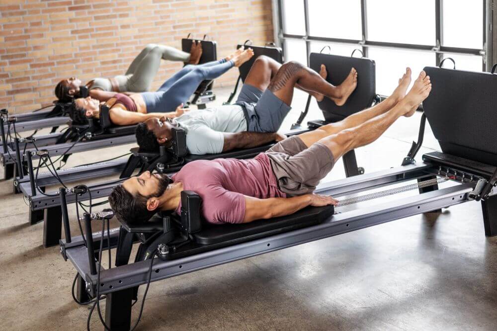 Люди занимаются на Allegro NextGen Reformers с Jumpboard'ами.