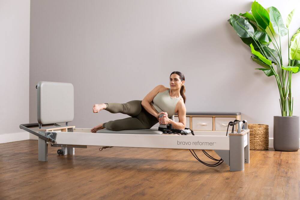 Женщина использует Jumpboard для Bravo Reformer в студии пилатеса.